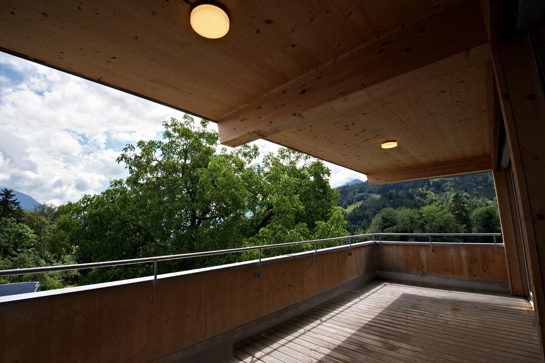 Überdachte Terrasse mit Blick ins Grüne – Wohnen mit Bergblick